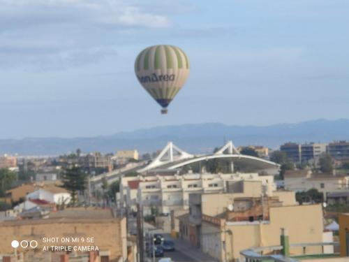 a hot air balloon flying over a city at L'àtic dels flamencs in Sant Jaume d'Enveja