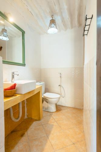 un bagno con un lavandino bianco e un water di ZANZI Apartment a Zanzibar City