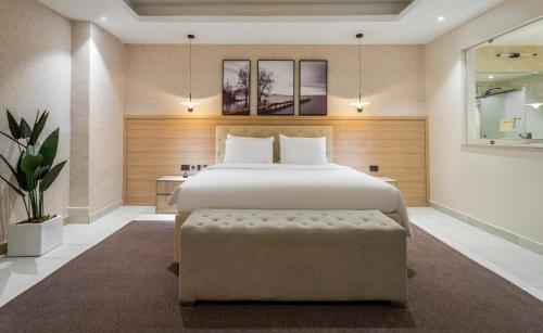 a bedroom with a large bed with a bench in it at Charles Fancy in Ilado