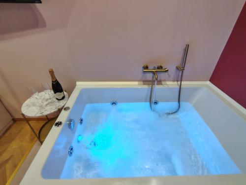 a blue tub with a shower and a bottle of wine at Drea Acitrezza Luxury Home in Acitrezza