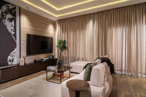a living room with a white couch and a tv at Charles Fancy in Ilado