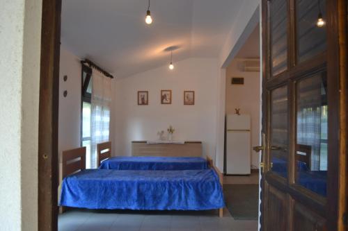 a bedroom with a blue bed and a refrigerator at Vikendica na rancu Lisa in Ivanjica