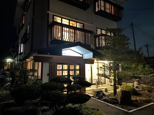 a building with a lit up window at night at Guest House HIIRAGI in Yamanakako