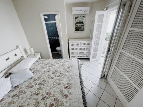 a bedroom with a bed and a door to a bathroom at Home 80 I Casa em condomínio pé na areia em Juquehy WIFI e Piscina in São Sebastião