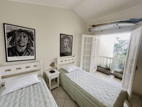 a bedroom with two beds and a window at Home 80 I Casa em condomínio pé na areia em Juquehy WIFI e Piscina in São Sebastião