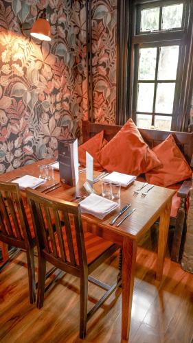 a wooden table with two chairs and a couch at The Shoulder of Mutton in Calverton