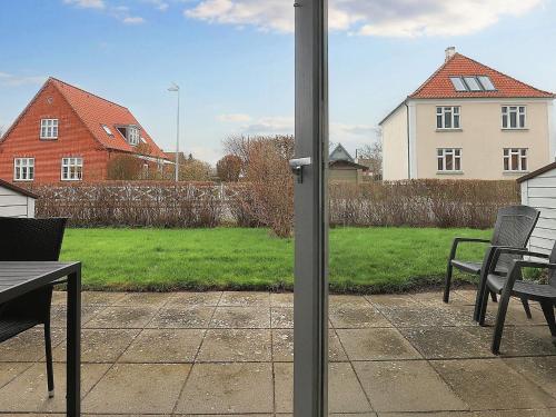 a patio with a table and chairs and a house at 4 person holiday home in Ærøskøbing-By Traum in Ærøskøbing