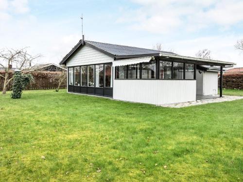 a house with a lot of windows and a green yard at 6 person holiday home in Nordborg in Nordborg