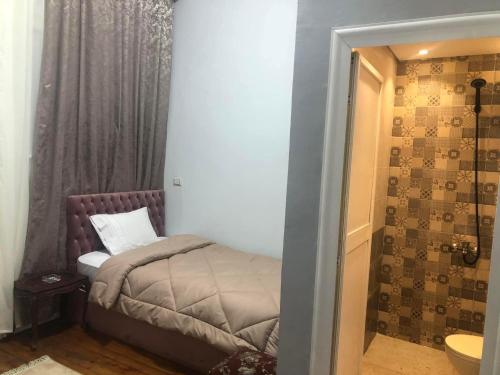 a small bedroom with a small bed and a shower at Bella Centro Citta in Cairo