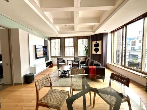 ケープタウンにある#803 Cartwright - Comfort in Prime Locationのガラスのテーブルと椅子のあるリビングルーム