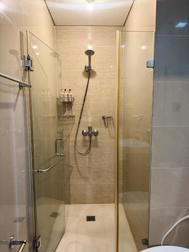 a bathroom with a shower with a glass door at Kai cabins NAIA 3 walking distance Newport City Pasay in Manila