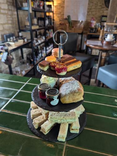 a three tiered plate of food with sandwiches and bread at The Duke Hotel in Hilmarton