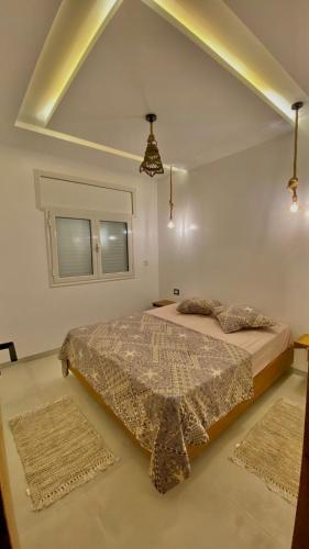 a bedroom with a bed and two rugs at Dar Lebharr Kélibia in Kelibia