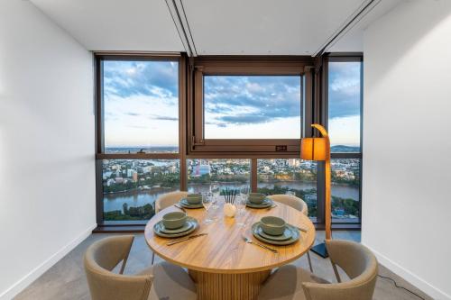 a dining room with a table and chairs and a large window at Queen's Wharf - Lv48 2Bedroom apt next to the Star in Brisbane