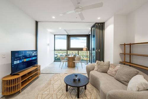 a living room with a couch and a tv at Queen's Wharf - Lv48 2Bedroom apt next to the Star in Brisbane