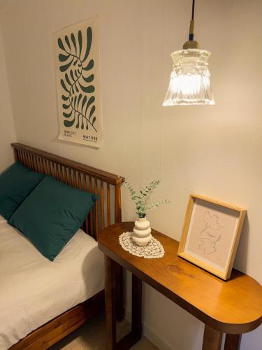 a bedroom with a table with a bed and a picture at Sun Gangnam Stay in Seoul