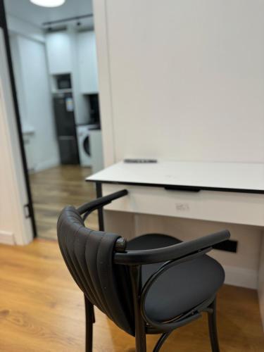 a black chair sitting in front of a desk at Bed and kitchen in Almaty