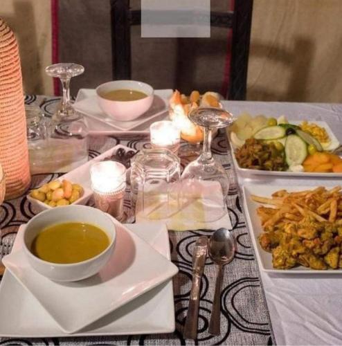 a table with plates of food and a bowl of soup at Cafe Restaurant Moove Oil in Rissani