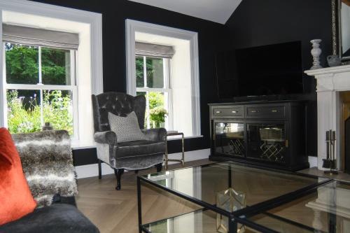a living room with a fireplace and a glass coffee table at Luxury Croft Templepatrick Near Airport Rabbit and Hilton hotel in Templepatrick