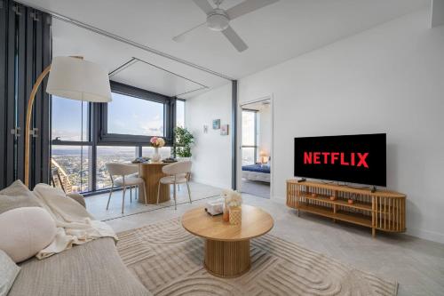 a living room with a tv and a table at Queen's Wharf 1Bed Apt - Lv 60 Skyline Reverie in Brisbane