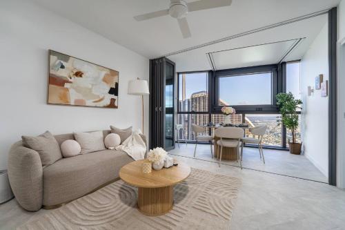 a living room with a couch and a table at Queen's Wharf 1Bed Apt - Lv 60 Skyline Reverie in Brisbane