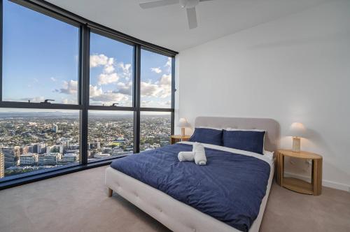 une chambre avec un grand lit et de grandes fenêtres dans l'établissement Wake Up to a Masterpiece - Lv 60 Skyline Reverie, à Brisbane