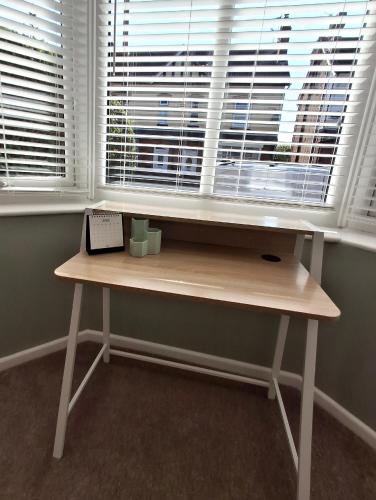 a wooden desk in front of a window with a keyboard at Alfreton Town Contractor Stay in Alfreton