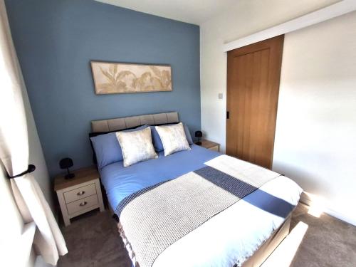 a bedroom with a bed with a blue wall at Alfreton Town Contractor Stay in Alfreton