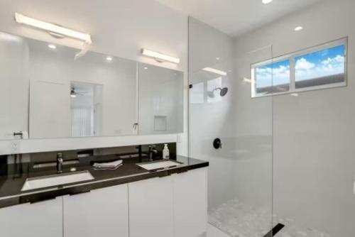a white bathroom with a sink and a shower at Modern 3BED 2BATH House in Fort Lauderdale in Fort Lauderdale
