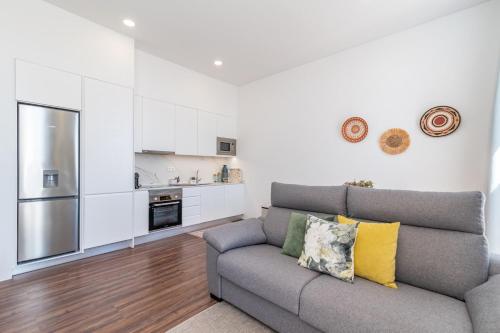 a living room with a couch and a kitchen at T2 Luxo Mobilado in Figueira da Foz