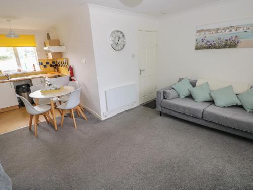 a living room with a couch and a table at Awel-Y-Mor in Swansea