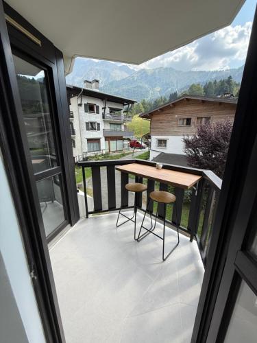 a balcony with a table and two stools at Appartement 1 Chambre in Les Houches
