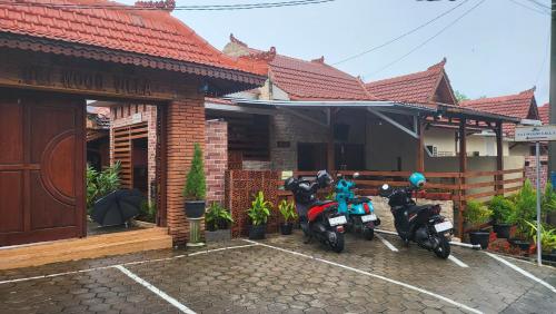 dos motocicletas estacionadas en un estacionamiento frente a una casa en Uli Wood Villa, Jimbaran BALI - near GWK, en Jimbaran