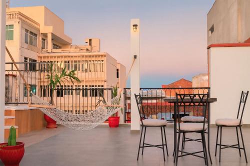 a hammock on a balcony with a table and chairs at Sarao in Santa Cruz de la Sierra
