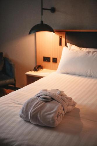 a towel laying on a bed in a hotel room at Hotel Infante Santo - Lisboa in Lisbon