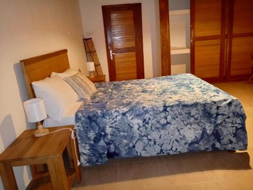 Un dormitorio con una cama con una manta azul. en Villa Awa, en Rufisque