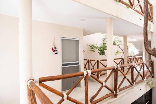 a staircase in a house with a wooden railing at 1 block from the Ocean, comfy condo with pool view in Progreso