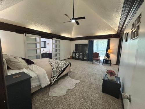 une chambre avec un lit et un ventilateur de plafond dans l'établissement La casa del Arbol, à Tulsa