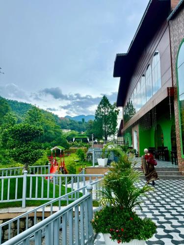 a person standing outside of a building with a playground at GOOSENECK HOTEL and RESTAURANTS in Kandogal