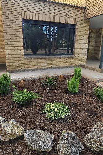 a garden with rocks and flowers in front of a building at Chez Marie in La Muela