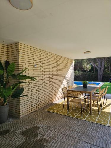 a patio with a table and chairs and a brick wall at Chez Marie in La Muela