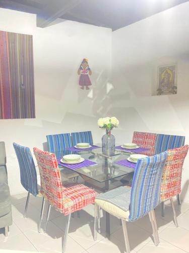 a dining room with a glass table and blue chairs at Casa Charlotte Antigua in Antigua Guatemala