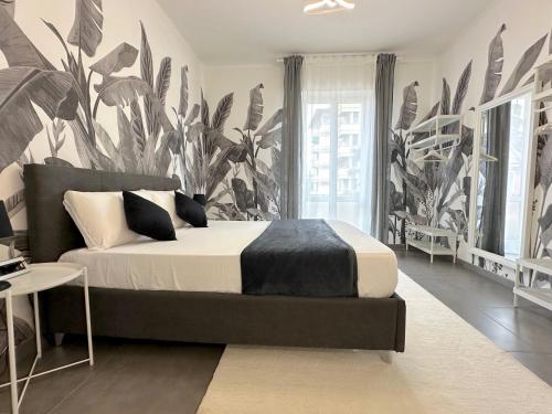 a bedroom with a bed with a large plant wallpaper at Villa Laura Appartamento in Bologna