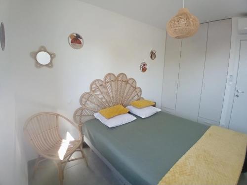 a bedroom with a green bed and a chair at T2 neuf situation Topissime village de Cargèse Vue mer Toutes commodités in Cargèse
