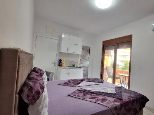 a bedroom with a bed with a purple blanket on it at Kan&Dzan Apartmani in Ulcinj