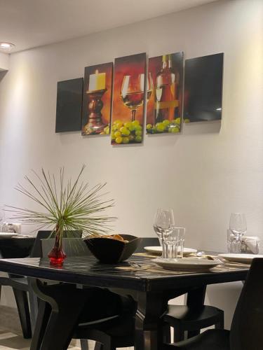 a dining room with a table with a painting on the wall at Little Ranch Hotel Spa Pilar in Manuel Alberti