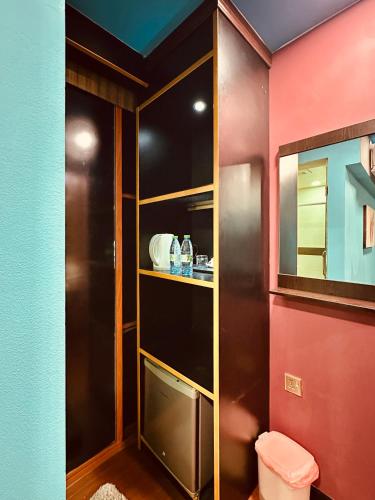 a bathroom with a toilet and a red wall at Rara HM in Male City