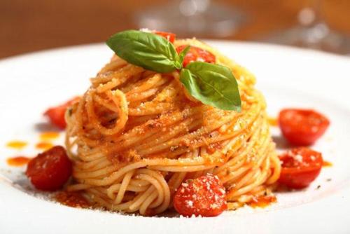 a plate of pasta with a green leaf on top at Little Ranch Hotel Spa Pilar in Manuel Alberti