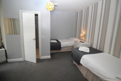 a hotel room with two beds and a mirror at The Sefton Hotel in Bridlington