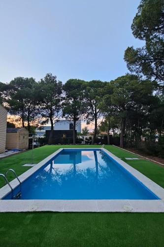a swimming pool in a yard with green grass at Chez Marie in La Muela